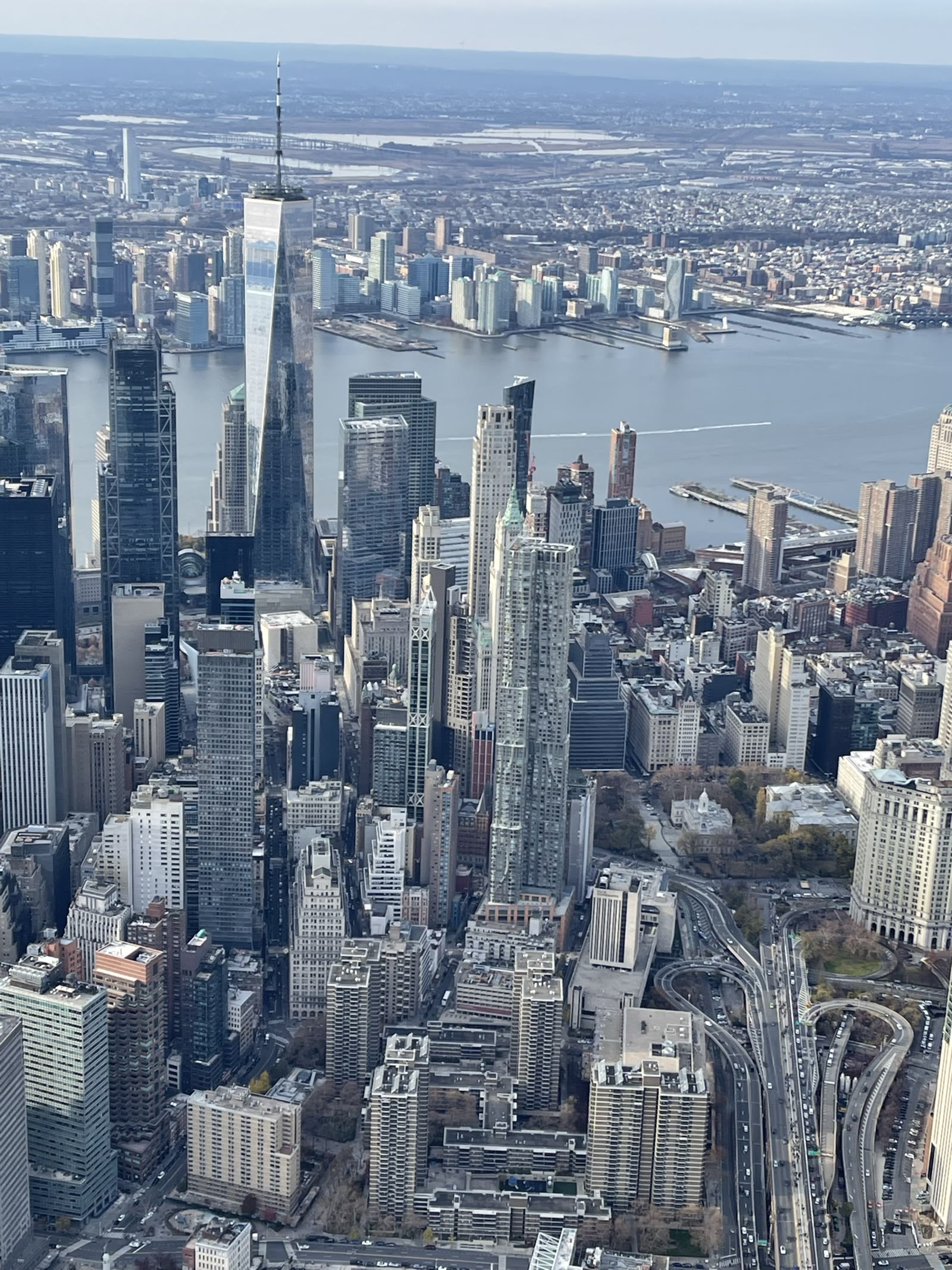 High aerial photograph of the Lower Manhattan skyline with One World Trade Center and the Hudson River